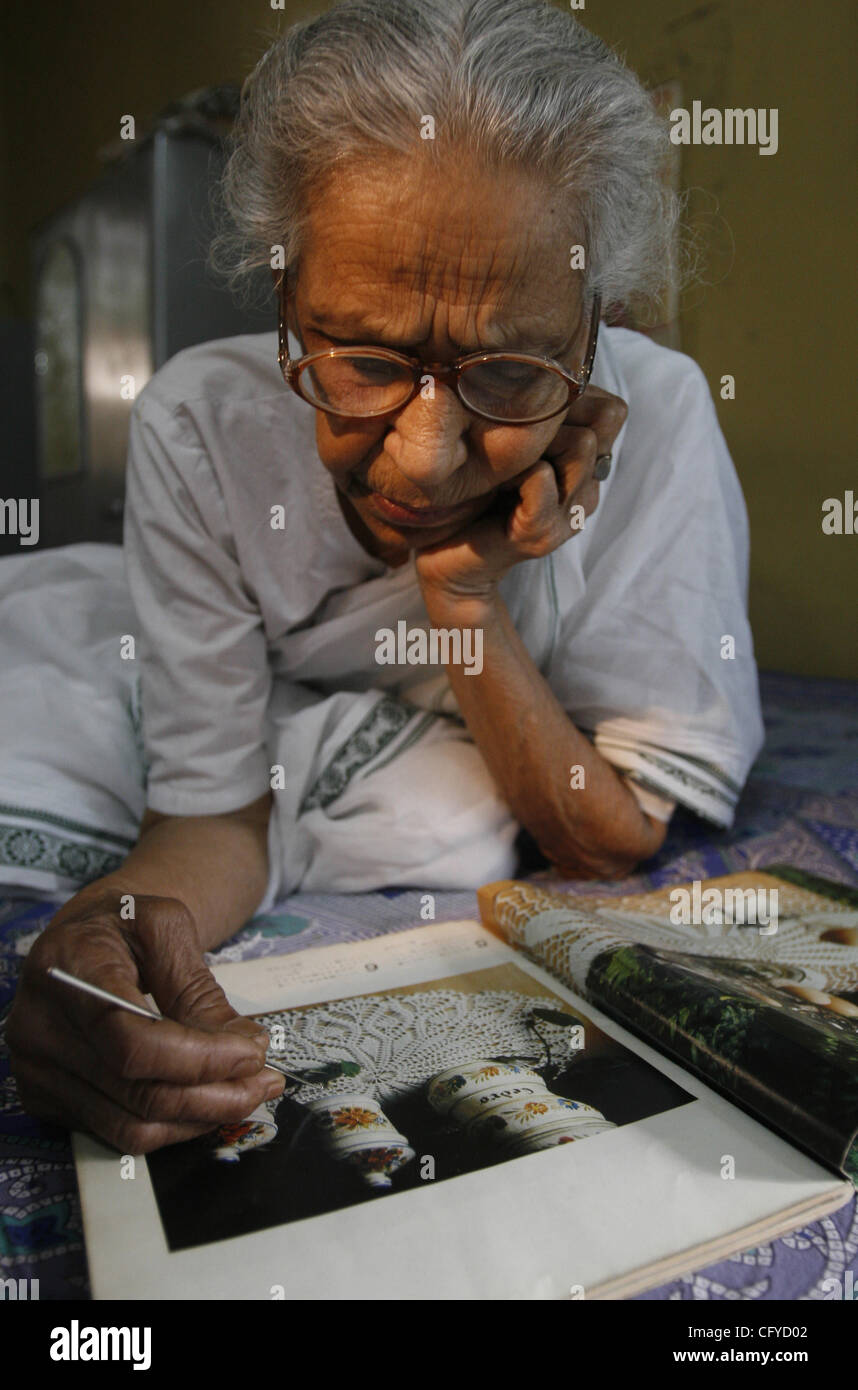 Sumitra Mukherjee, 80, looks through an art magazine as she relaxes on her bed (number 12) at an Old Age Home in New Delhi, India on Tuesday May 15, 2007, celebrated as the International Family Day.  Photographer: Pankaj Nangia Stock Photo