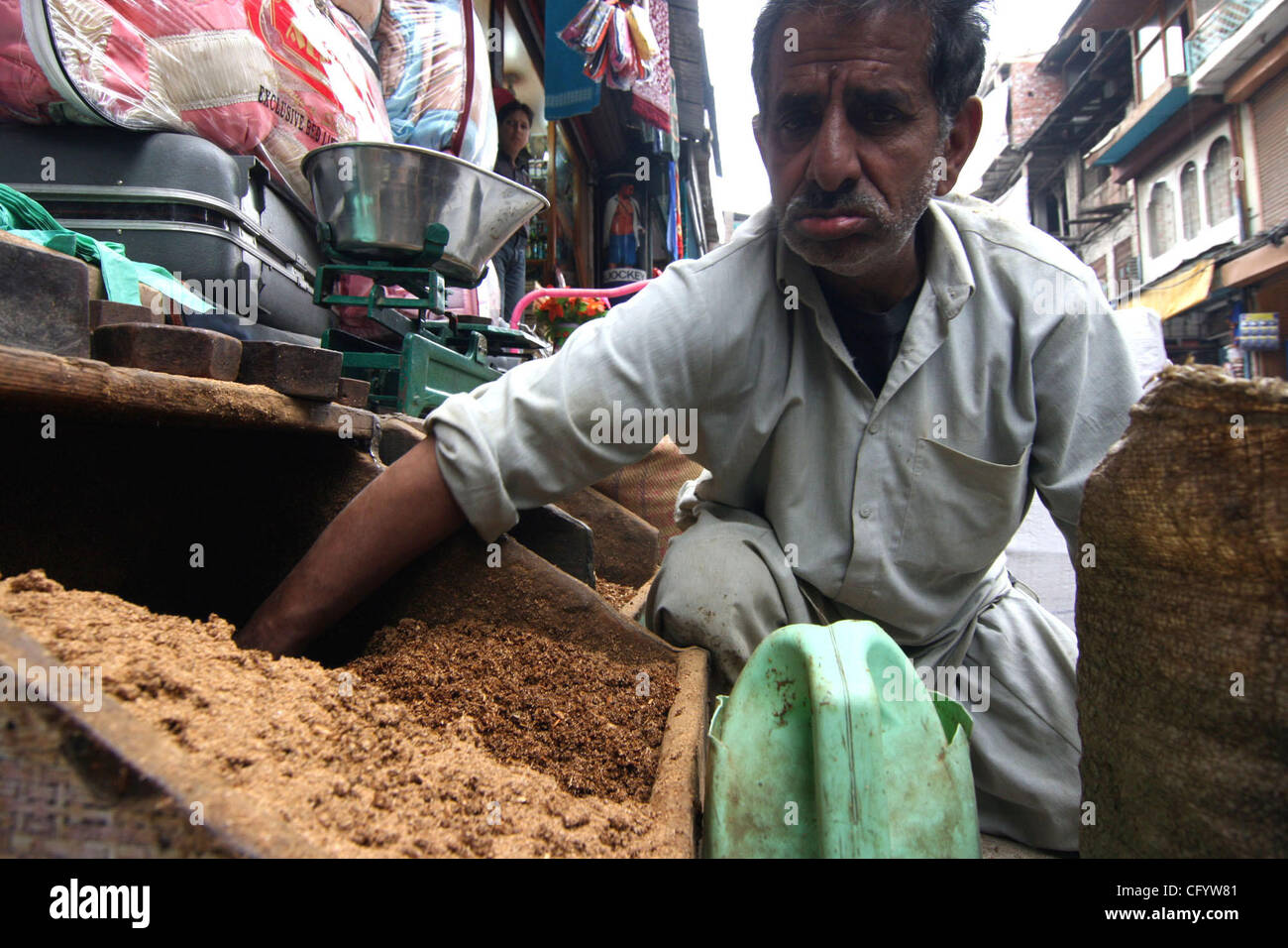 A Kashmiri tobacco seller collects tobacco in his hand for selling in  kashmir india. this tobacco is used in cigrattes and smoking pipes which  are used by people for smoking. Smoking in