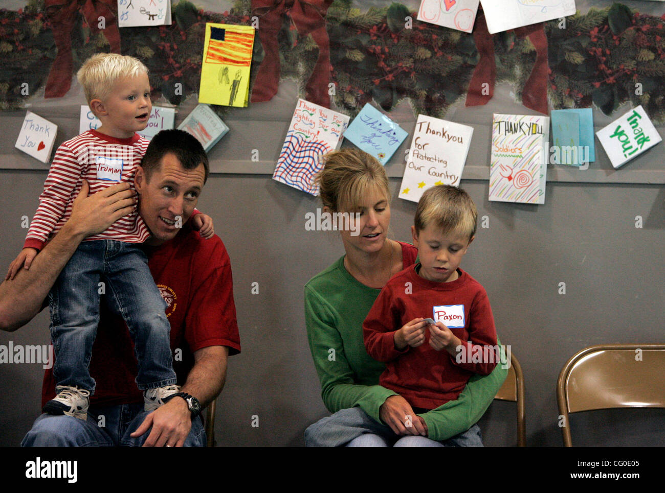June 25, 2007 San Diego, CA TONY PORTER of Rancho Bernardo, and his son, TRUMAN, 2, left, wife KAREN and son PAXON, 4, right, sit in a decorated gymnasium at the Murphy Canyon Youth Center in Tierrasanta, looking at raffle tickets during the 'The Christmas You Missed' event for military families. TO Stock Photo