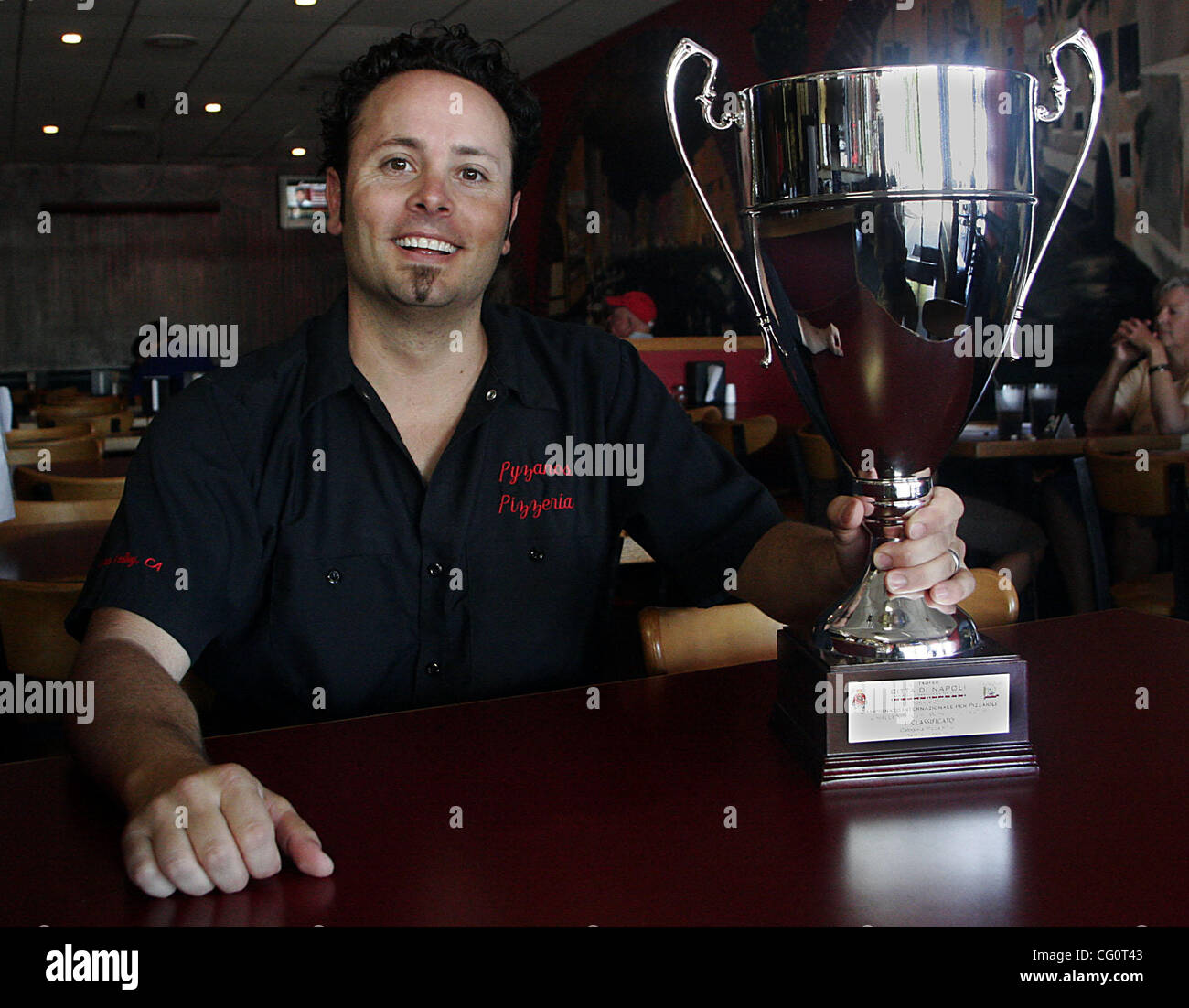 Tony Gemignani, recent winner of the World Pizza Cup pizza cooking contest in Naples, Italy, poses with his trophy at Pyzano's Pizza in Castro Valley, Calif. on Friday, July 13, 2007.  (Dean Coppola/Contra Costa Times) Stock Photo