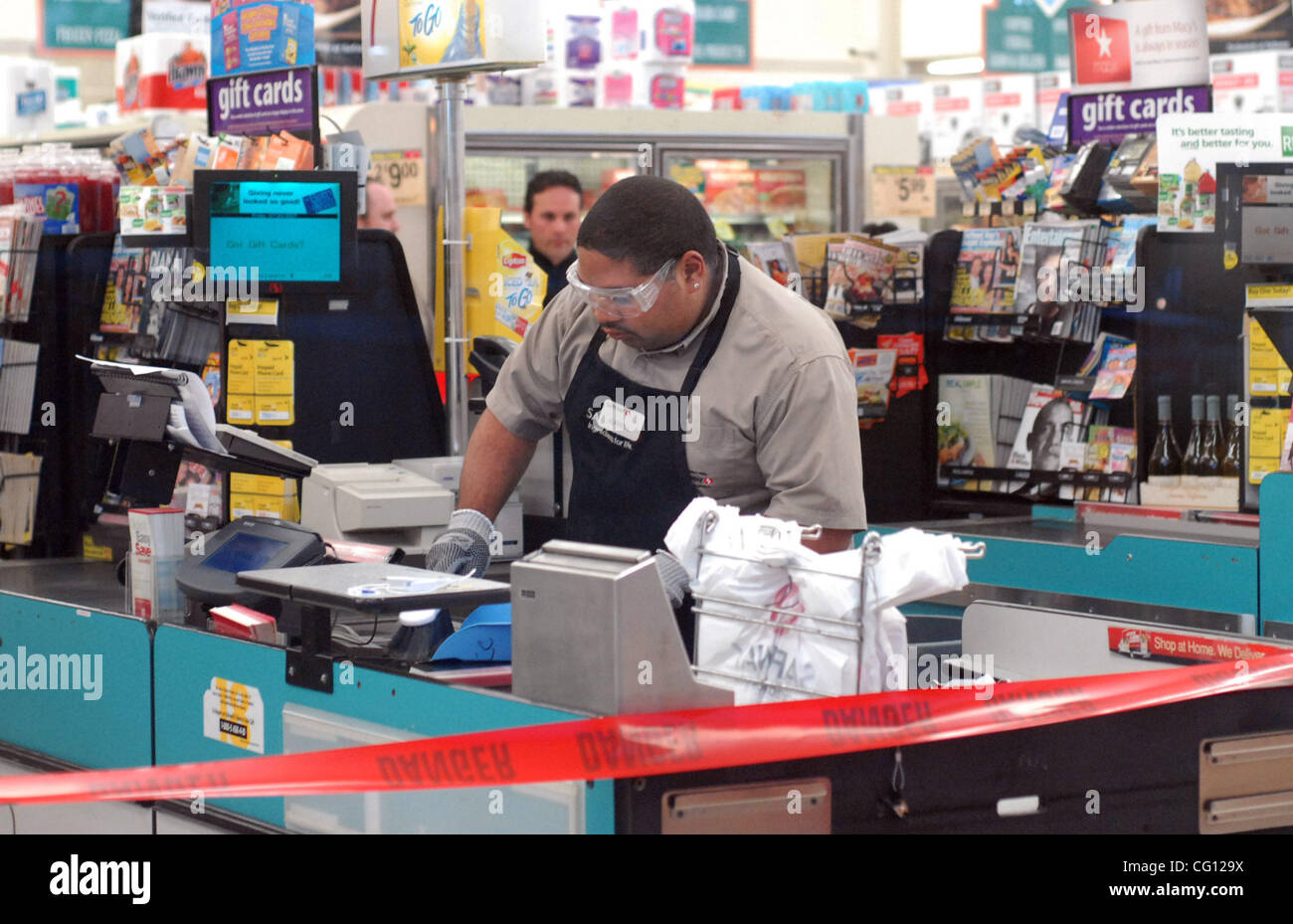 A Safeway employee cleans up in the area where a two windows shattered