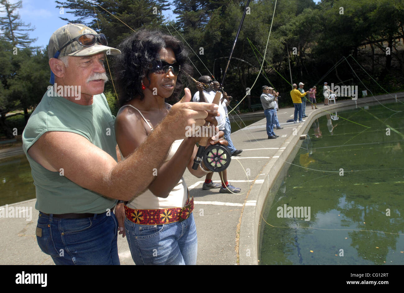 The Oakland Casting Club's Lessons Coordinator John Wurzel of Antioch,  Calif., (left) helps Denise Mapes of Oakland, Calif., (right) with her fly  casting during the clubs free casting lessons held at McCrea