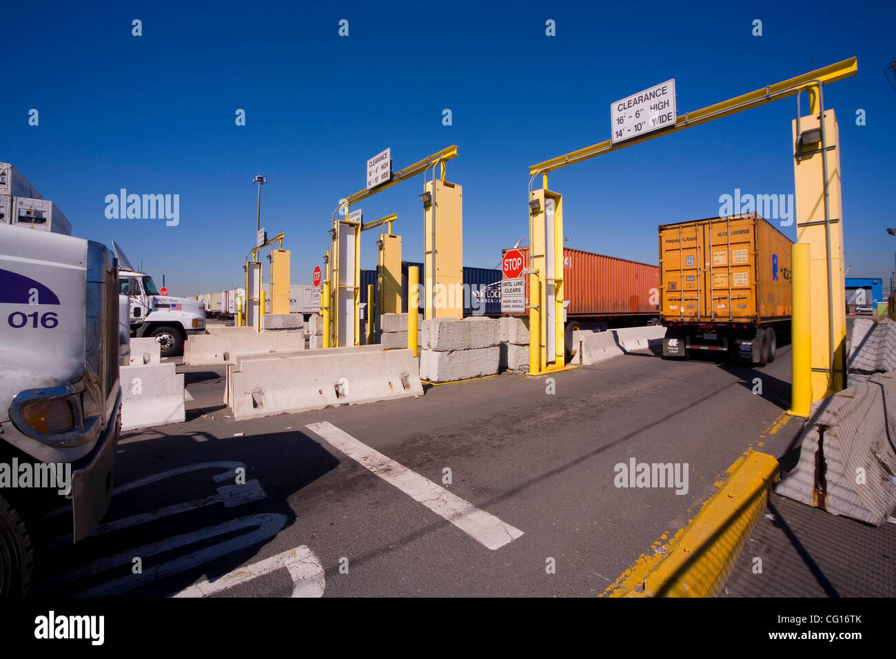 Trucks carrying maritime cargo containers prepare to pass between