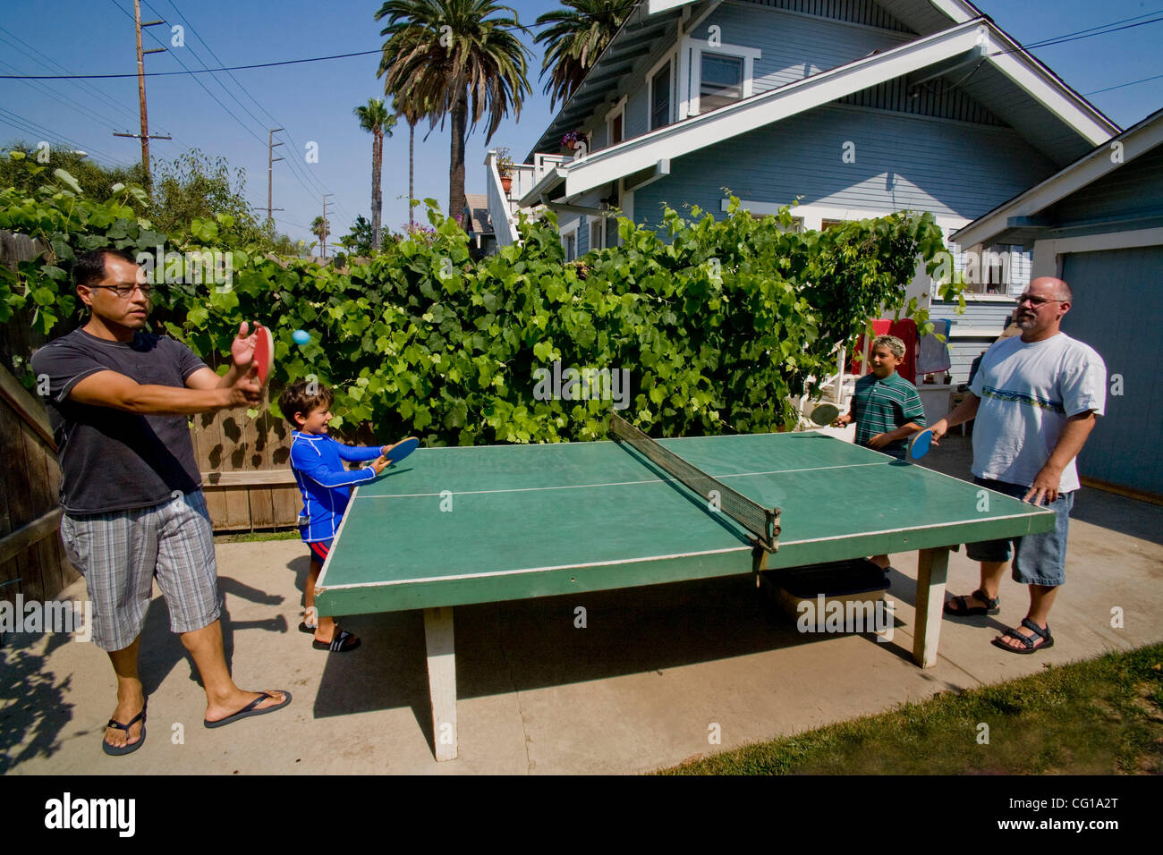 The gay adoptive fathers of five- and a ten-year-old boys play outdoor ping  pong with their sons in their backyard in Long Beach, CA Stock Photo - Alamy