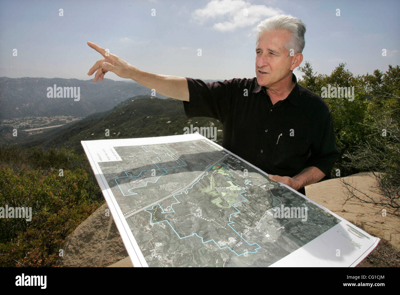 August 6, 2007, North of Escondido, California, USA JOE PERRING, project manager of proposed Merrriam Mountains development, points north in this view looking southeast as he holds a map of the place while standing on one of the higher hills in the northern Preserve section of the development. In th Stock Photo