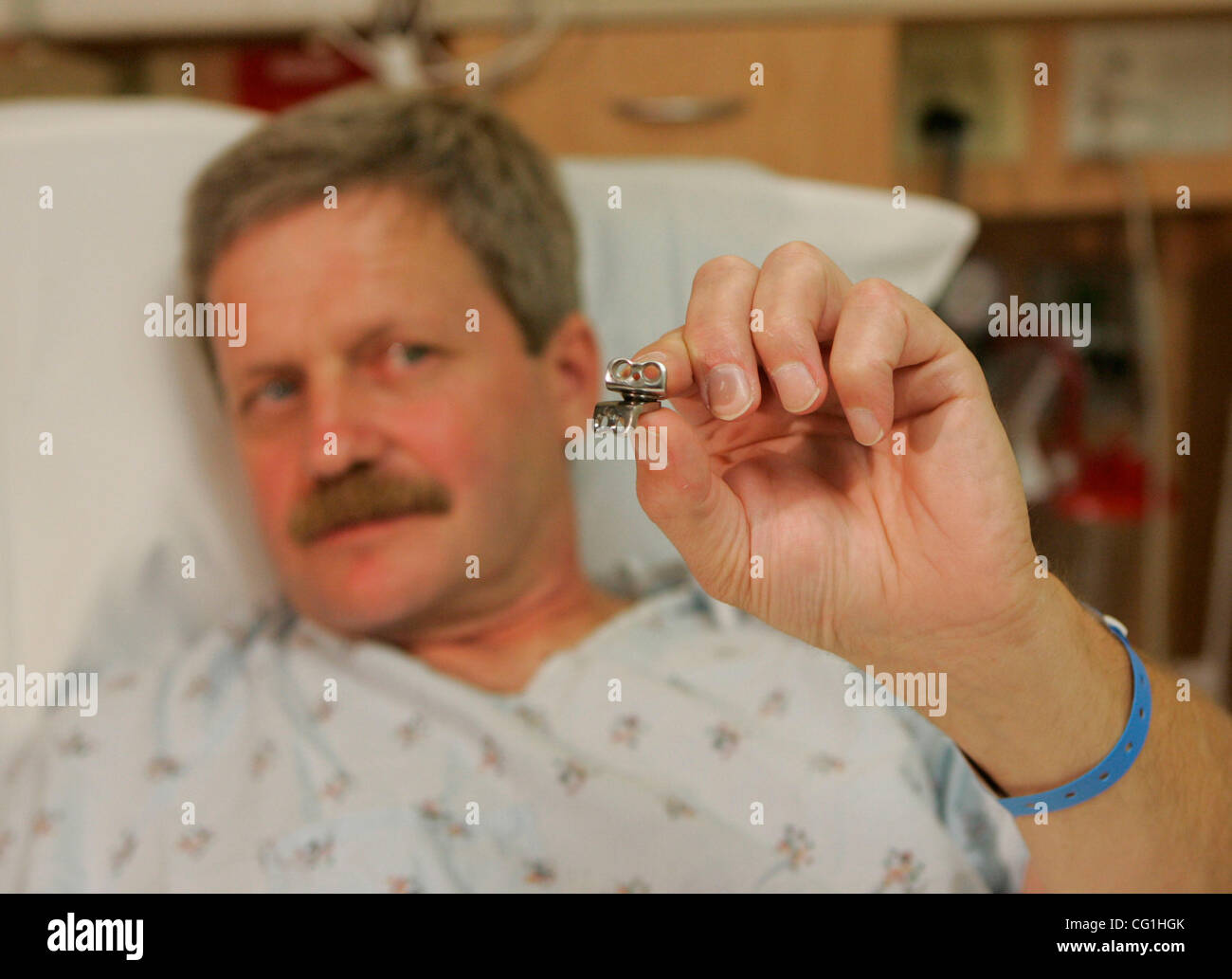 Aug 16, 2007 - Portland, OR, USA - TODD TRENAMAN, of Warren, OR, shows the Prestige Cervical Disc, similar to the one that will be implanted in his neck during surgery at the Oregon Health & Science University hospital. The device, approved by the FDA in July, is the first artificial disc commercial Stock Photo