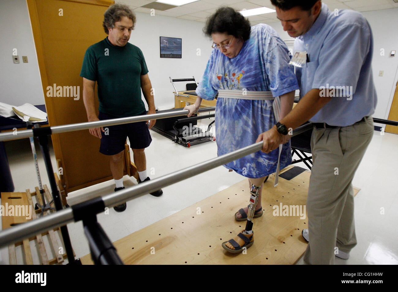 Aug 16, 2007 - Atlantis, FL, USA - Elissa Wehner walks on the parallel bars with the help of her physical therapist, Kenneth O' Sullivan, while her husband, Tom Wehner looks on.  Elissa Wehner goes to rehabilitative therapy at JFK hospital's outpatient facility on August 16, 2007 (Credit Image: © J. Stock Photo