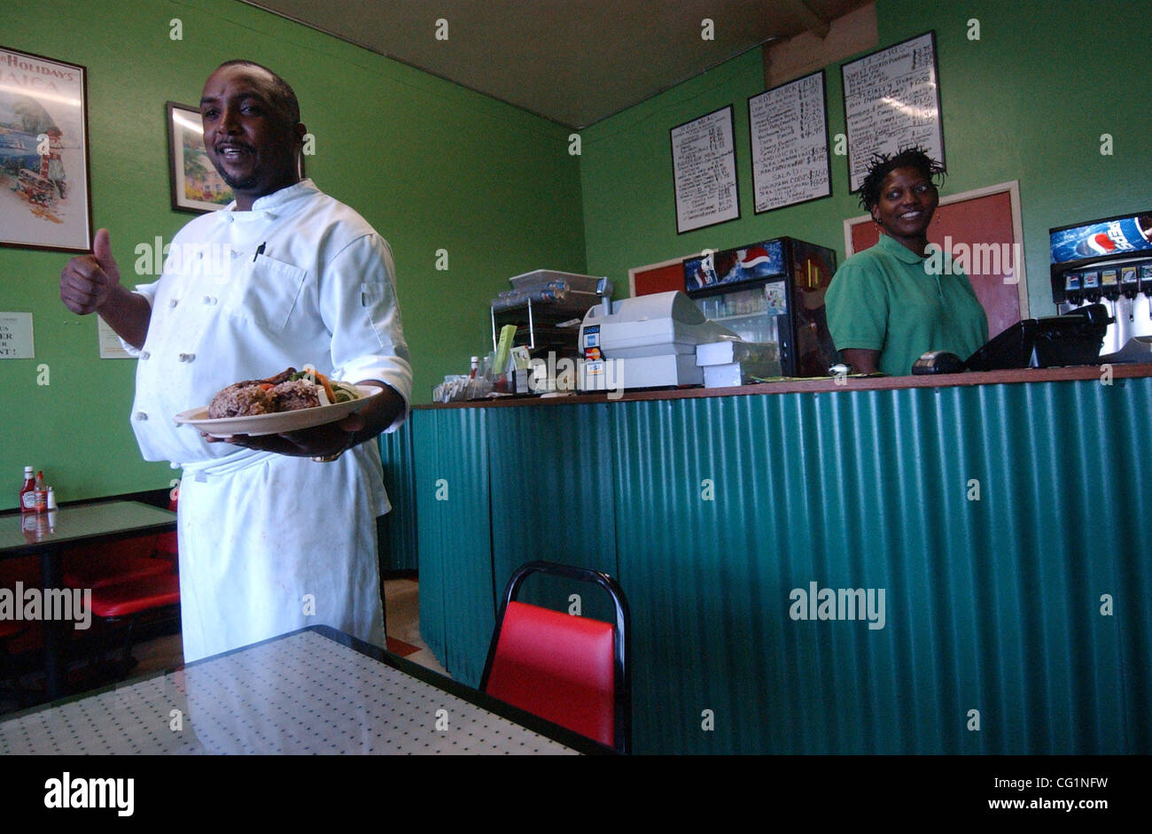 Jerk chicken and salmon combo is served by chef Robert Simpson, left
