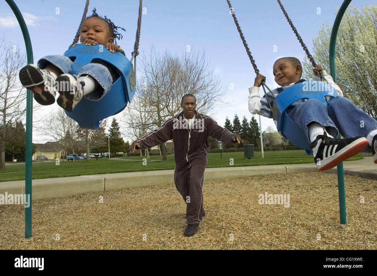 At a park near his home, Tyrone Rhinehart pushes sons, Daniel, 1, left, and Joshua, 3. The Sacramento Bee/  Anne Chadwick Williams/  March 7, 2007 Stock Photo
