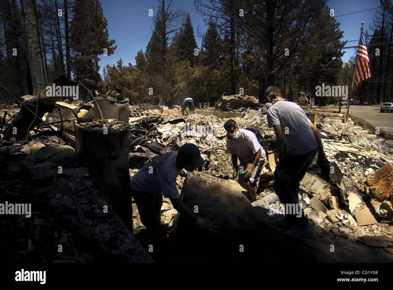 From left, Bill Mohr, Dan Jensen and Josh Sprague of Reddlands help clear rubble from the home of Norma and Warren Sprague after a massive fire ripped through South Lake Tahoe this week.  Mohr's home was destroyed and Jensens's was not. Several neighbors, both who had lost their homes and had lost t Stock Photo