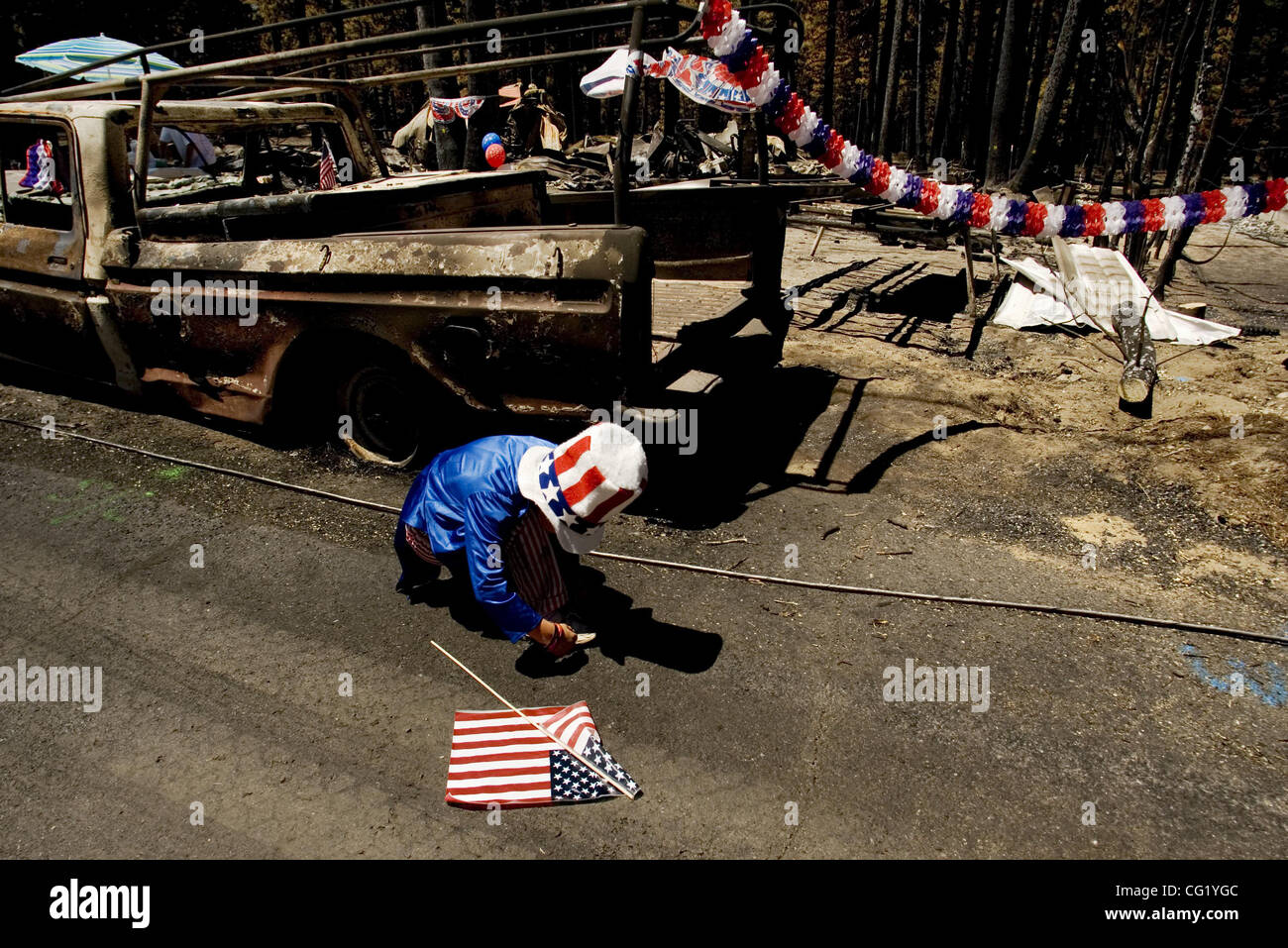 Taylor Stokes, 8, of Mindon ties his shoes before a neighborhood parade in the burned out area of South Lake Tahoe July 4, 2007.  Brandon and his family came to celebrate the holiday with Brandon's uncle and aunt, Paul and Lynda Jack who's home on Pyramid Circle was burned to the foundation.  The pa Stock Photo