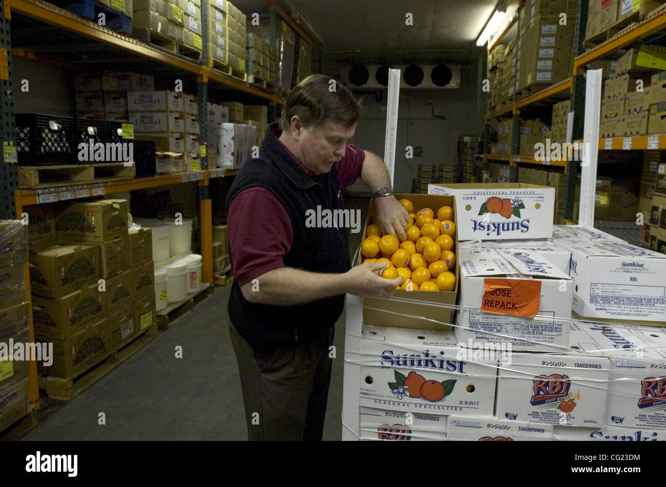 Rick Bateman (cq), buyer at the General Produce Company shows the damage to tangerines that have