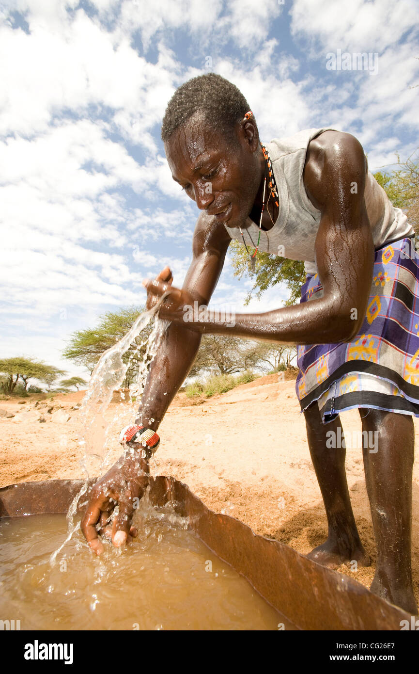August 5, 2011, Isiolo, Kenya - Pastoralist Lmetianai Lesibia uses water collected from a small hand-dug sand well to wash after watering his livestock in the same hole. Sharing water sources with animals is unhealthy, but limited access to water makes it a necessity. (Credit Image: David Snyder/ZUM Stock Photo