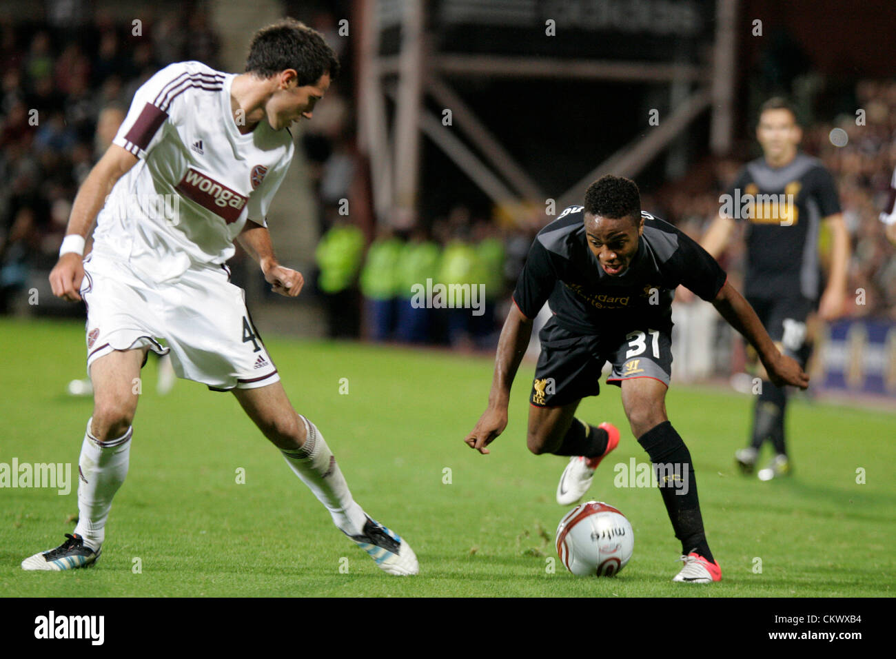 23.08.2012 Edinburgh, Scotland. 31. Raheem Sterling and 4 Ryan McGowan in action during the Europa League Qualifying 1st leg tie between Hearts and Liverpool from the Tynecastle Stadium. Hearts lost 0-1 to an own goal in the first leg. Stock Photo