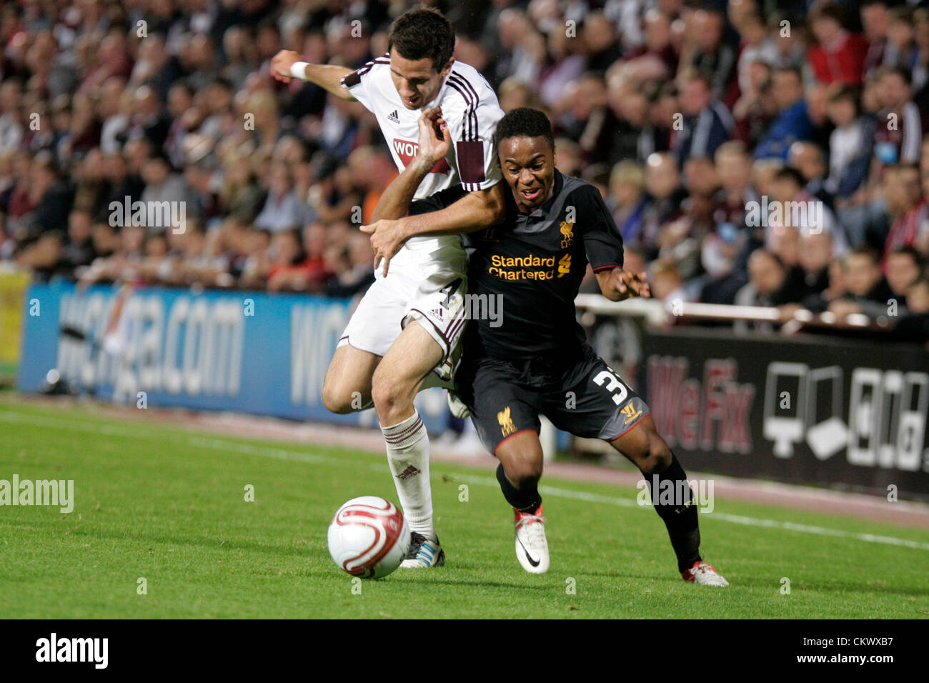 23.08.2012 Edinburgh, Scotland.  4 Ryan McGowan and 31. Raheem Sterling in action during the Europa League Qualifying 1st leg tie between Hearts and Liverpool from the Tynecastle Stadium. Hearts lost 0-1 to an own goal in the first leg. Stock Photo