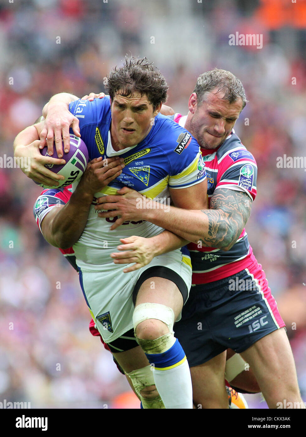 25th Aug 2012. Leeds Rhinos v Warrington Wolves  Carnegie Challenge Cup Final 2012 Leeds Rhinos Jamie Peacock tries to hold back Ben Harrison Stock Photo