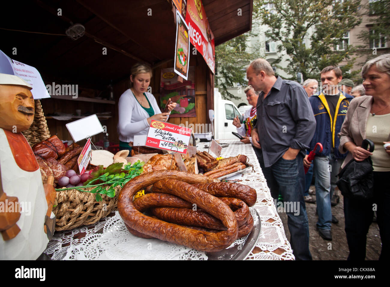 August 26, 2012 Cracow, Poland - Market stall with sausages and meats during annual traditional Polish food festival. Shown sausage (pol. - kiełbasa) is a food usually made from ground meat with a skin around it. Sausage making is a traditional food preservation technique. Sausages may be preserved by curing, drying, or smoking. Stock Photo