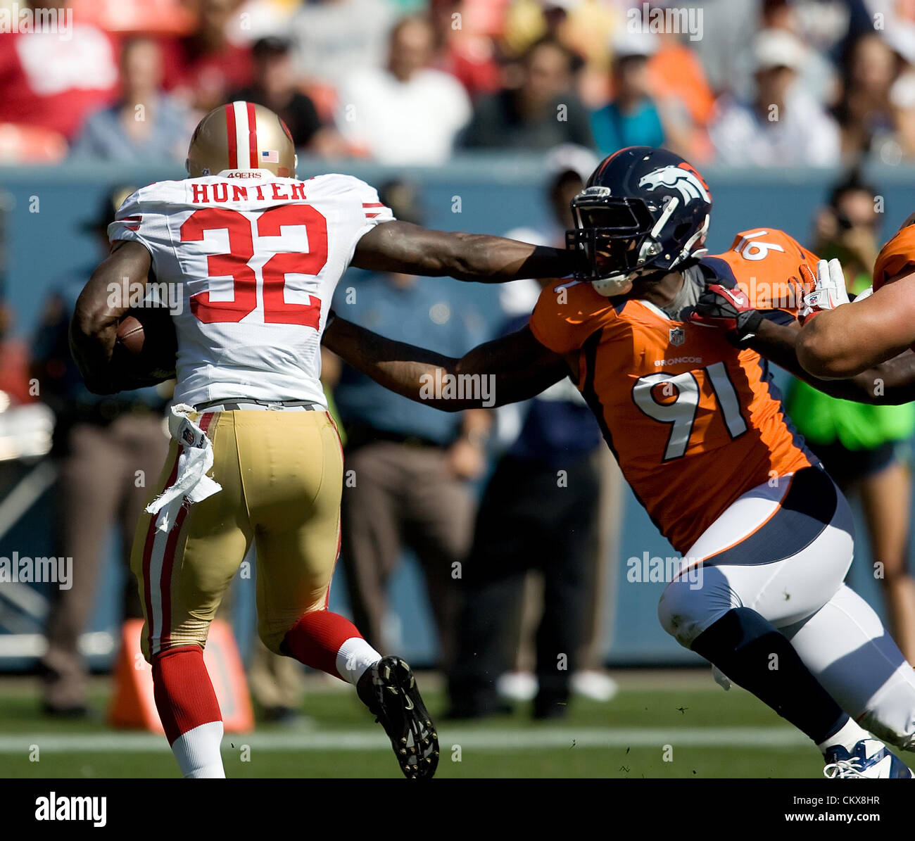 Aug. 26, 2012 - Denver, CO, USA - 49ers RB KENDALL HUNTER, left, avoids a tackle by Broncos DE ROBERT AYERS, right, during the 1st. half at Sports Authority Field at Mile High Sunday afternoon. The Broncos lose to the the 49ers 29-24. (Credit Image: © Hector Acevedo/ZUMAPRESS.com) Stock Photo