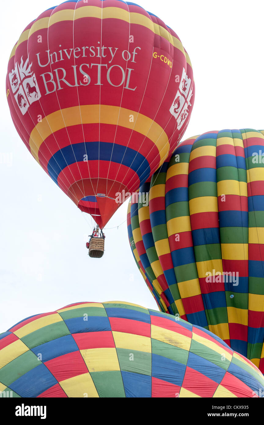 26th Aug 2012. The John Harris (G-CDWD) University of Bristol balloon takes off beside the Colin Hodges G-CFFL Lindstrand LBL-317A Aerosaurus balloon at the Tiverton balloon festival in Tiverton, Devon, UK. Stock Photo