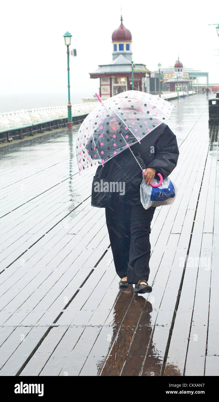 27th August 2012  Wet and windy weather in Blackpool on the last summer bank holiday of the year kept the holiday crowds away.Women battling her way along North Pier. Credit:  kevin walsh / Alamy Live News Stock Photo
