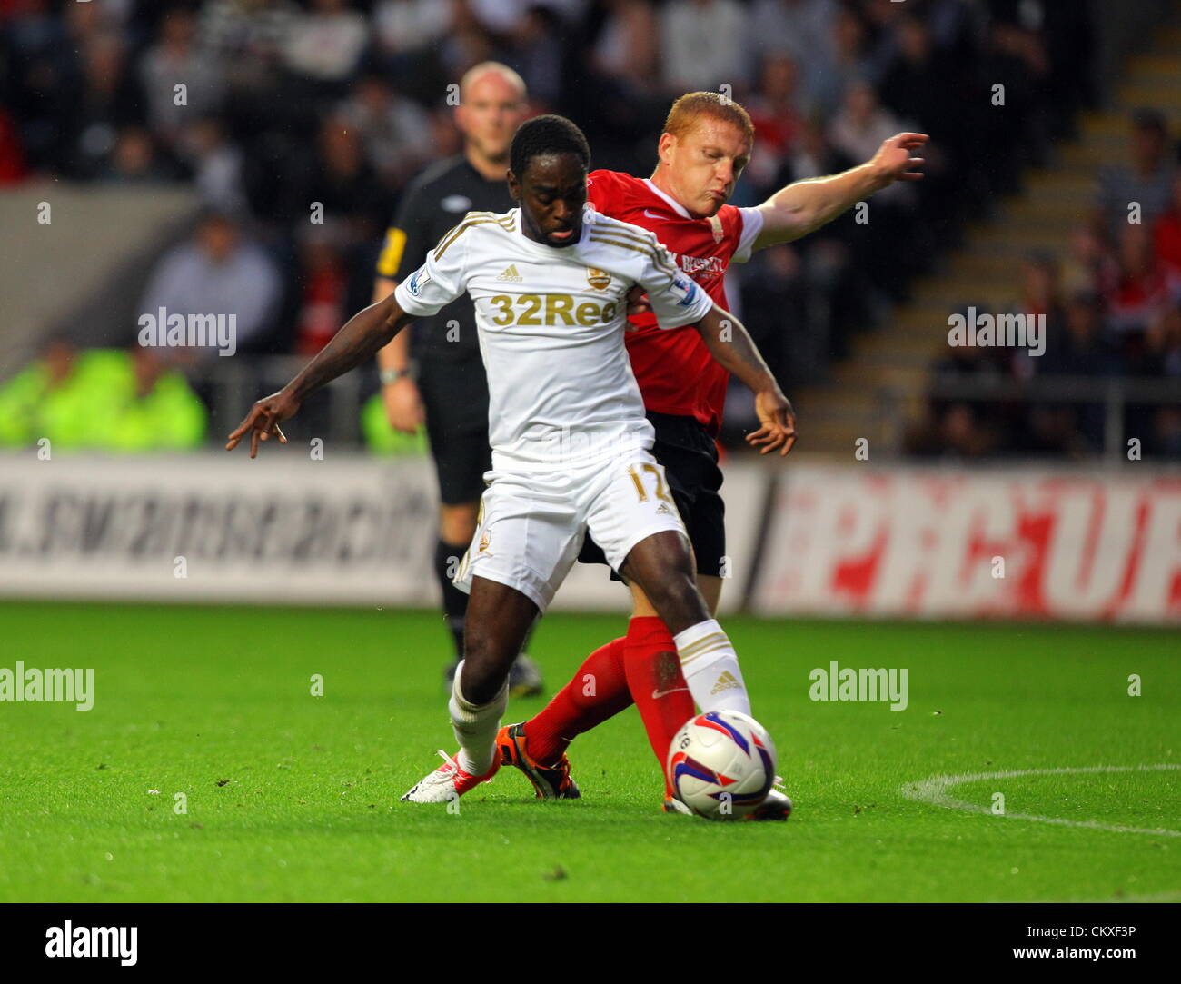 Liberty Stadium, Swansea, UK. 28th Aug 2012.  Pictured L-R: Nathan Dyer of Swansea challenged by Bobby Hassell of Barnsley.  Capital One Cup game, Swansea City FC v Barnsley at the Liberty Stadium, south Wales, UK. Credit:  D Legakis / Alamy Live News Stock Photo