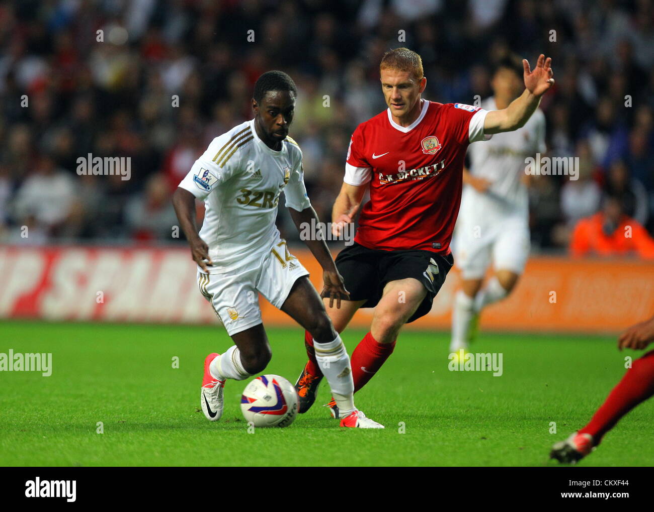 Liberty Stadium, Swansea, UK. 28th Aug 2012.   Pictured L-R: Nathan Dyer of Swansea challenged by Bobby Hassell of Barnsley. Capital One Cup game, Swansea City FC v Barnsley at the Liberty Stadium, south Wales, UK. Credit:  D Legakis / Alamy Live News Stock Photo
