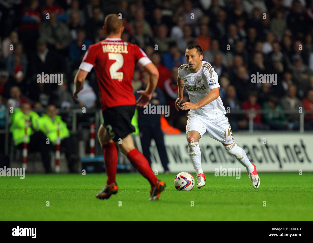 Liberty Stadium, Swansea, UK. 28th Aug 2012.   Pictured: Stephen Dobbie of Swansea (R) charging past Bobby Hassell of Barnsley (L). Capital One Cup game, Swansea City FC v Barnsley at the Liberty Stadium, south Wales, UK. Credit:  D Legakis / Alamy Live News Stock Photo