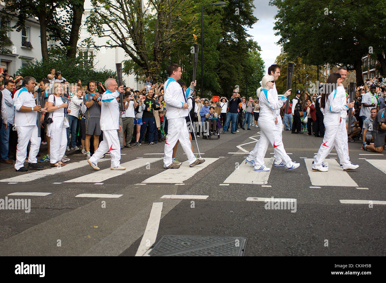 London, UK. 29th Aug 2012. Five of the torchbearers from among the 580 people specially chosen to carry the Paralympic flame on the last day of its journey to the Olympic Stadium, Wednesday 29 August 2012, are cheered across the zebra crossing outside the Abbey Road recording studios in St. John's Wood made famous by the Beatles. Credit: Richard Slater / Alamy Live News Stock Photo