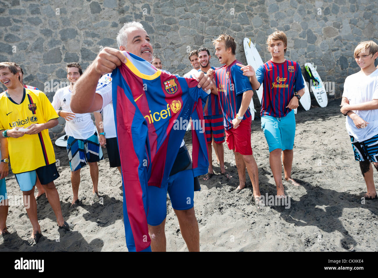 LAS PALMAS, CANARIAS ISLANDS, SPAIN–AUGUST 29, 2012: Unidentified young surfers from University Surf School and Surf Camp Las Palmas during an informal competition, formed as an football match with 11 surfers in each team, one team is wearing T-shirts from football club F.C. Barcelona, the other one from Real Madrid. Stock Photo