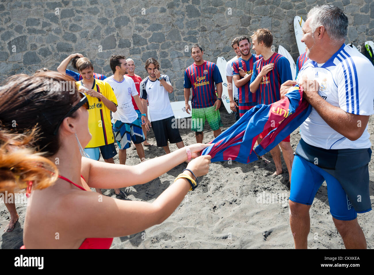 LAS PALMAS, CANARIAS ISLANDS, SPAIN–AUGUST 29, 2012: Unidentified young surfers from University Surf School and Surf Camp Las Palmas during an informal competition, formed as an football match with 11 surfers in each team, one team is wearing T-shirts from football club F.C. Barcelona, the other one from Real Madrid. Stock Photo