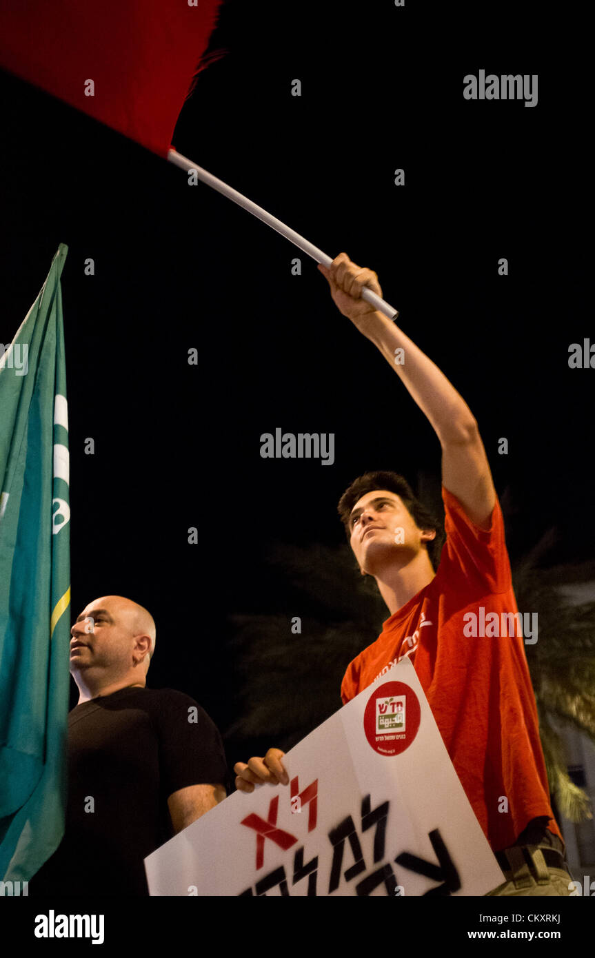Jerusalem, Israel. 30th Aug 2012. A young man waves a red flag and holds a sign reading “No to war on Iran” at Paris Square. Jerusalem, Israel. 30-August-2012.  Less than two dozen protest at Paris Square and march to the Prime Minister’s residence calling on PM Benjamin Netanyahu and Defense Minister Ehud Barak to drop intentions of a military strike on Iranian nuclear facilities. Stock Photo