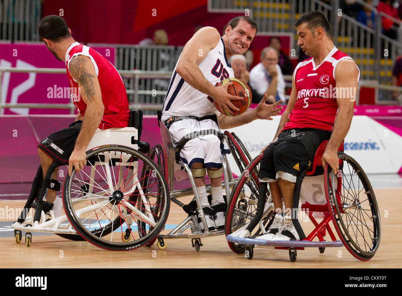 USA's Joshua Turek squeezes between two Turkish players during wheelchair basketball game at the 2012 London Paralympics. Stock Photo
