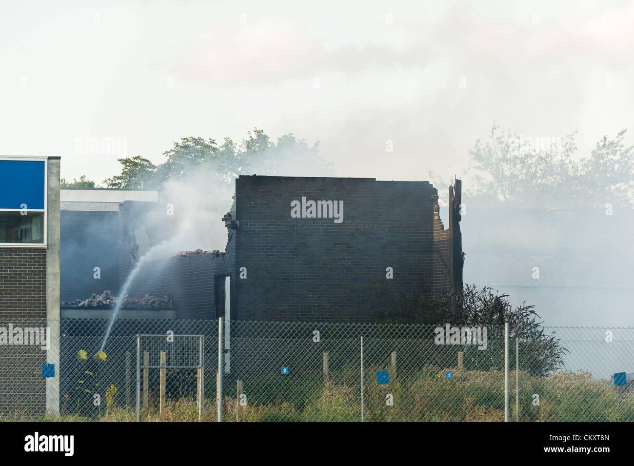 Coby, Northants, UK. 30th Aug 2012. Smoke arising from Kingswood secondary school's disused building (formerly Our Lady and Pope John school) as firemen put out a fire on the evening of thursday 30 august 2012 in the town of Corby, Northamptonshire. Stock Photo