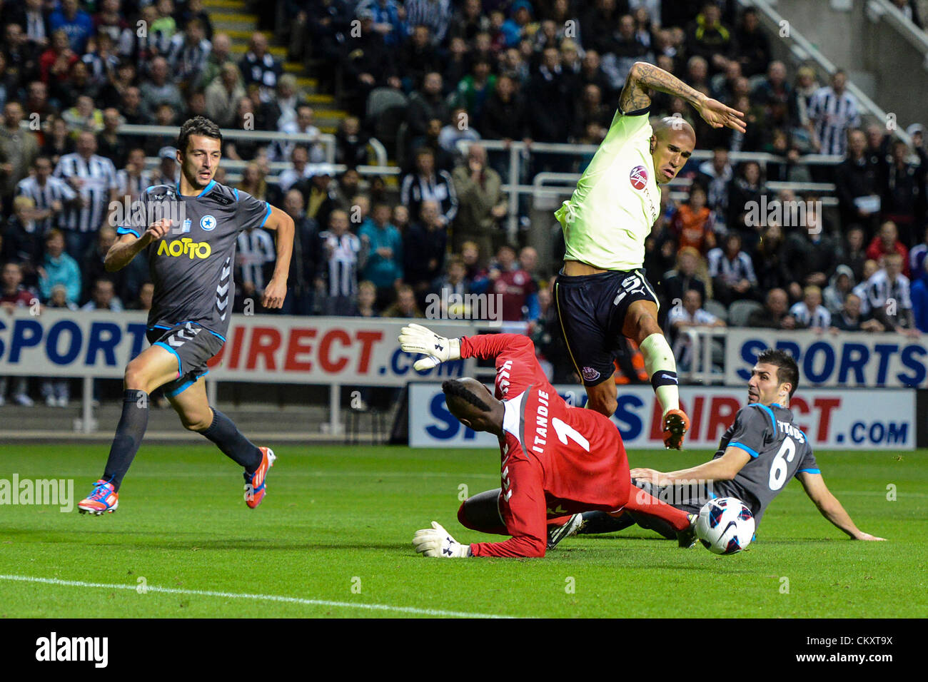 Newcastle, England. 30th Aug 2012. Newcastle's Gabriel Obertan leaps over Goal Keeper Charles Itandje and Sokratis Fytanidis during the Europa League Qualifying 2nd leg tie between Newcastle United and Atromitos from St James Park. Stock Photo