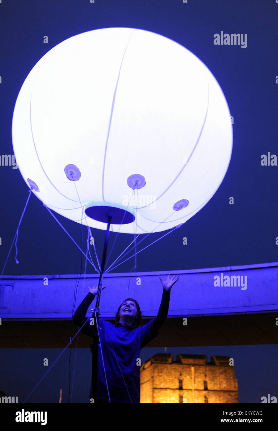 Carlisle, UK. 1st September, 2012. The Connecting Light art installation by New York based digital arts collective YesYesNo. Some 400 weather balloons with pulsating coloured LED lights were installed at various sites across the 73 miles of Hadrians Wall. Here a member of the public views one of the lights positioned on the Rotunda at the Tullie House Art Gallery and Museum in Carlisle, Cumbria that along with Carlisle Castle sits close to the line of Hadrian's Wall: 1 September 2012  STUART WALKER Stock Photo