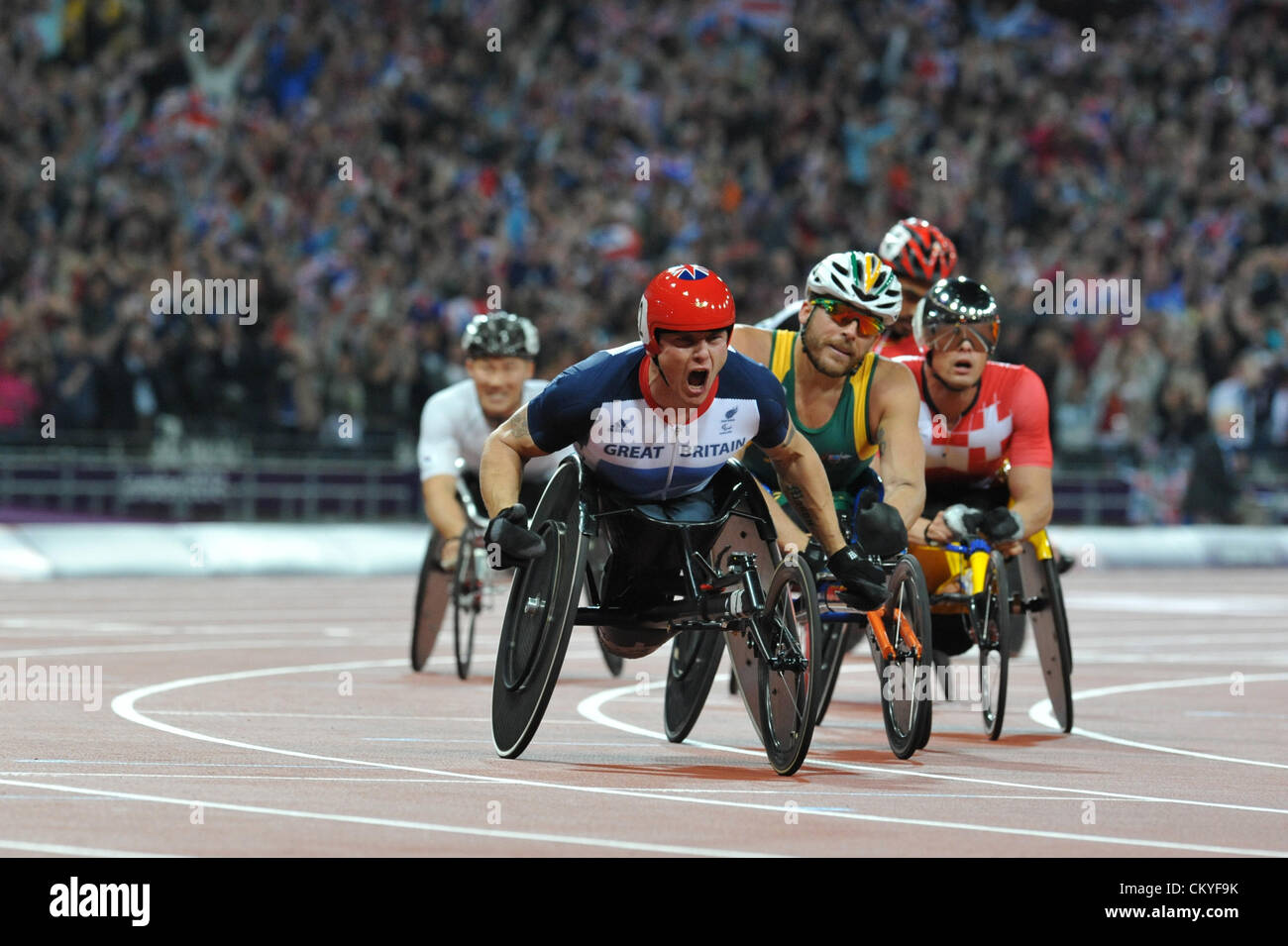 London, UK. 02 Sept 2012 - David Weir (GBR) reacts after winning the 5000m T54 final in the Olympic Stadium at the at the 2012 London Summer Paralympic Games. He is closely followed by Kurt Fearnley (AUS, second place) and Marcel Hug (SUI, fourth place). Partially visible in rear (L to R), Julien Casoli (FRA, third place) and Prawat Wahoram (THA, fifth place). (C) Michael Preston / Alamy Live News. Stock Photo