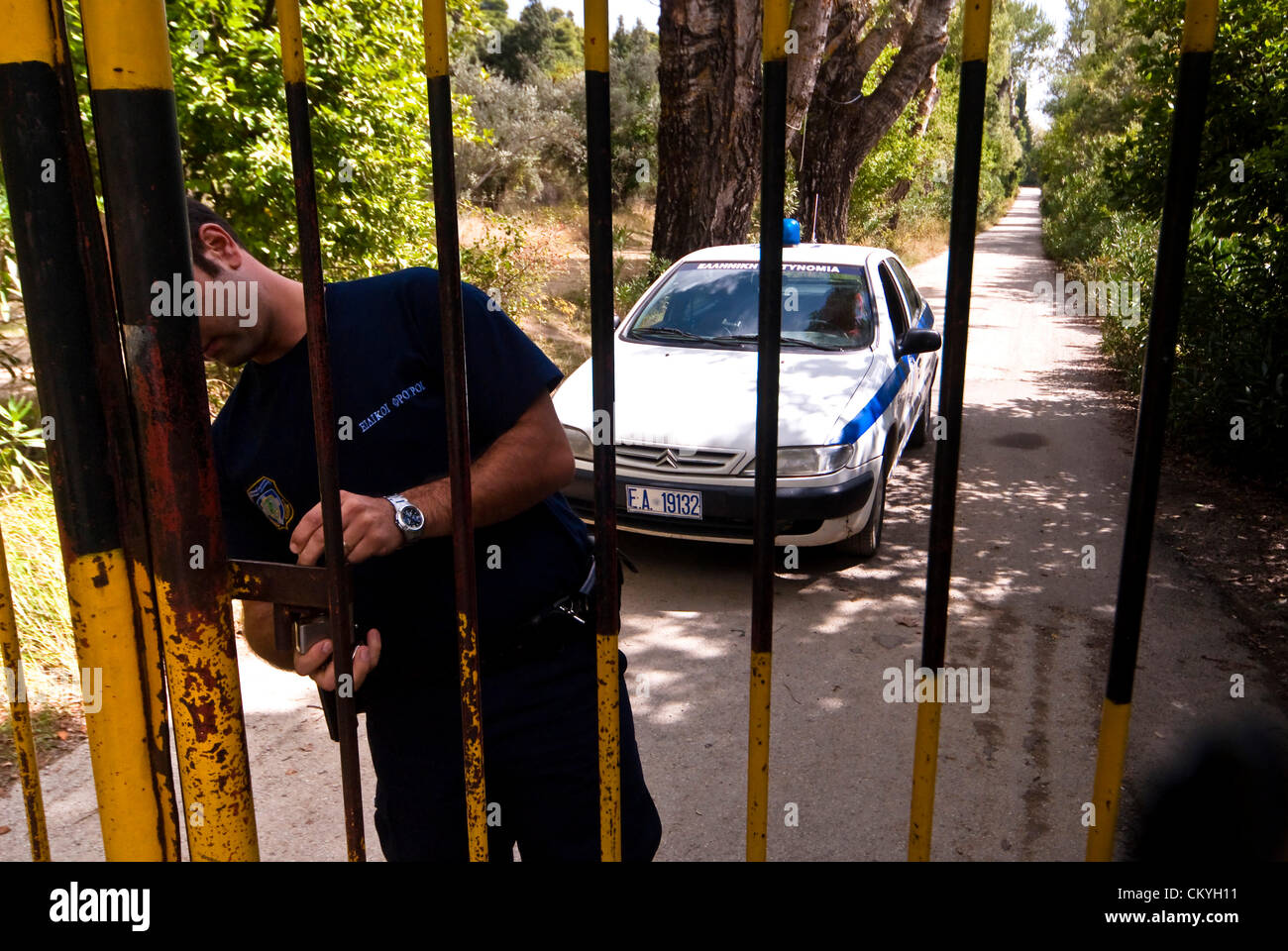Police officer opening the Gate -  Tatoi was originally the Summer Residence of the Greek Royal family which was eventually used as their year round home and the birthplace of King George II. The estate is located about 20kms north of Athens near to Dekeleia. About 1km from the main residency is the Greek Royal Cemetery. Part of the estate is also the royal farms. Photos from 2008. September 3rd 2012. Athens, Greece. The Greek government announced this week that the former Royal Estate of Tatoi was to be put up for sale or lease by the state privatization fund (TAIPED). Stock Photo