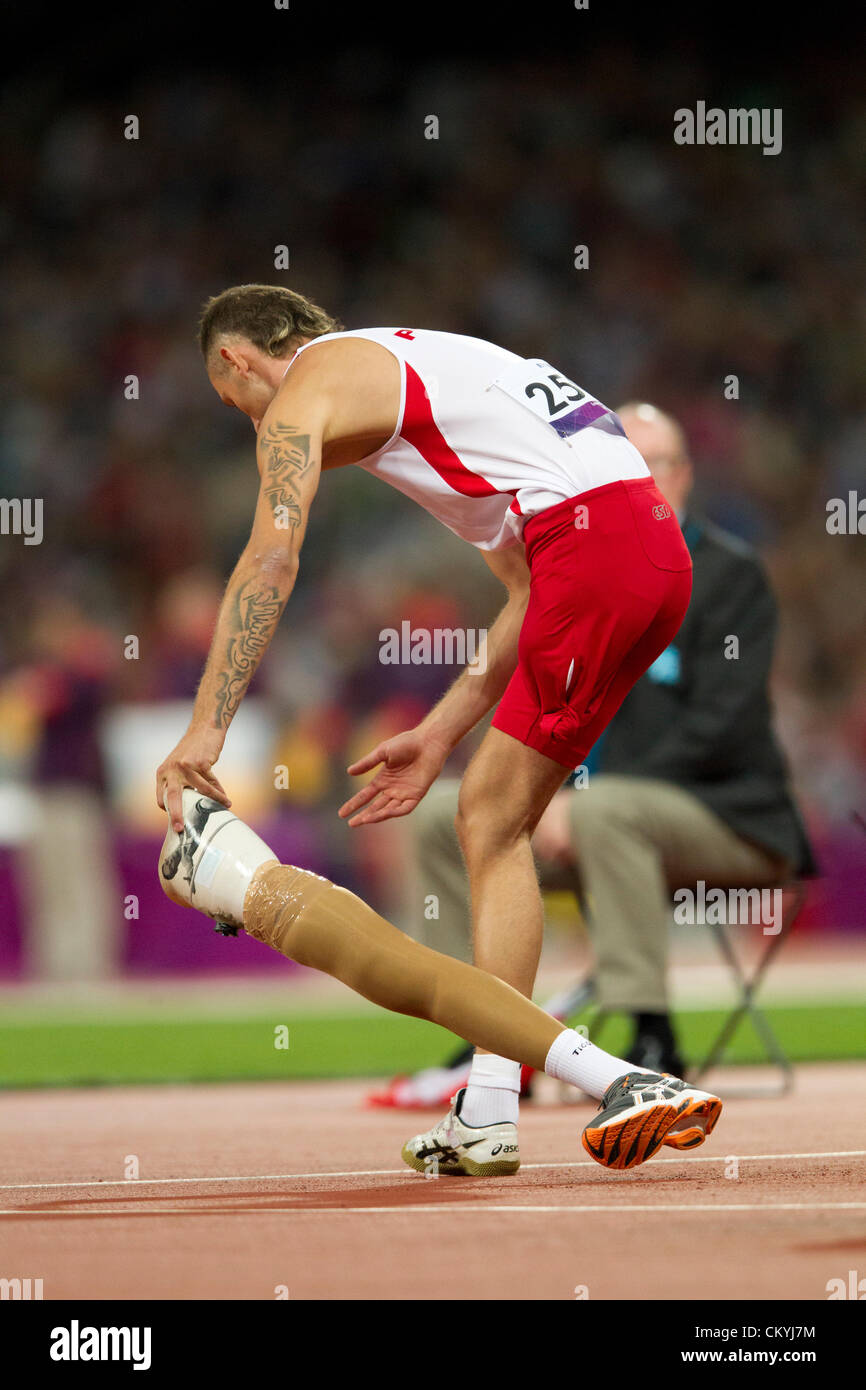 Poland's Lukasz Mamczarz removes his prosthetic leg before competing in the men's high jump F42 class at the Paralympics Stock Photo