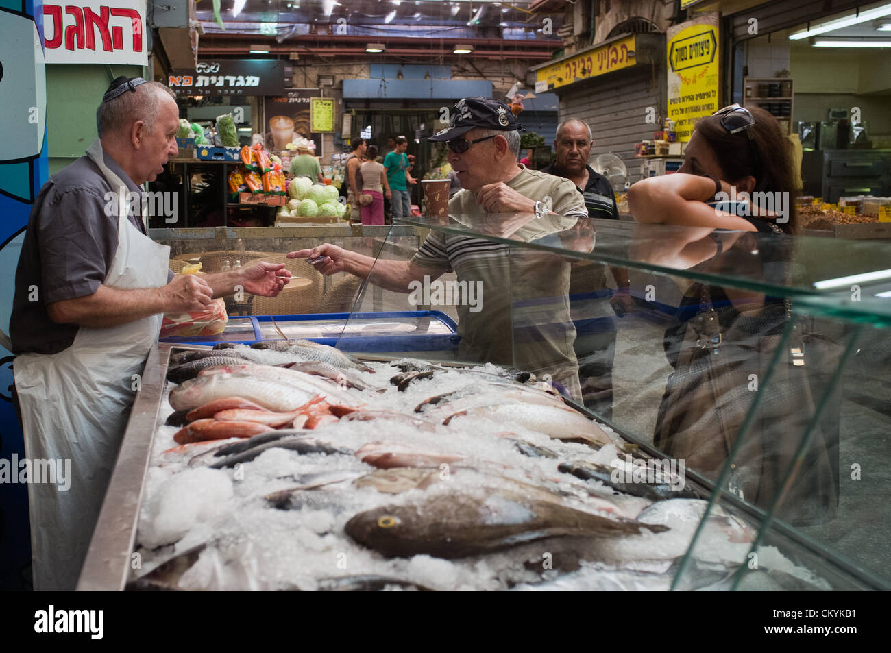 Customers purchase fresh fish at the Mahane Yehuda Market in