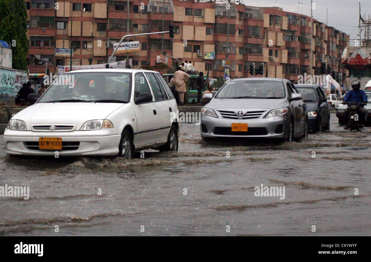 Commuters pass through rain water that was stand at water pump road