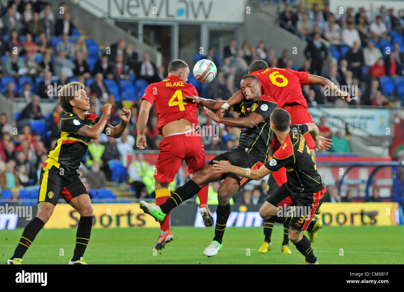 FIFA 2014 World Cup Qualifying Match - Wales v Belgium at the Cardiff City Stadium : Vincent Kompany of Belgium challenges Ashley Williams and Darcy Blake for the ball. Stock Photo