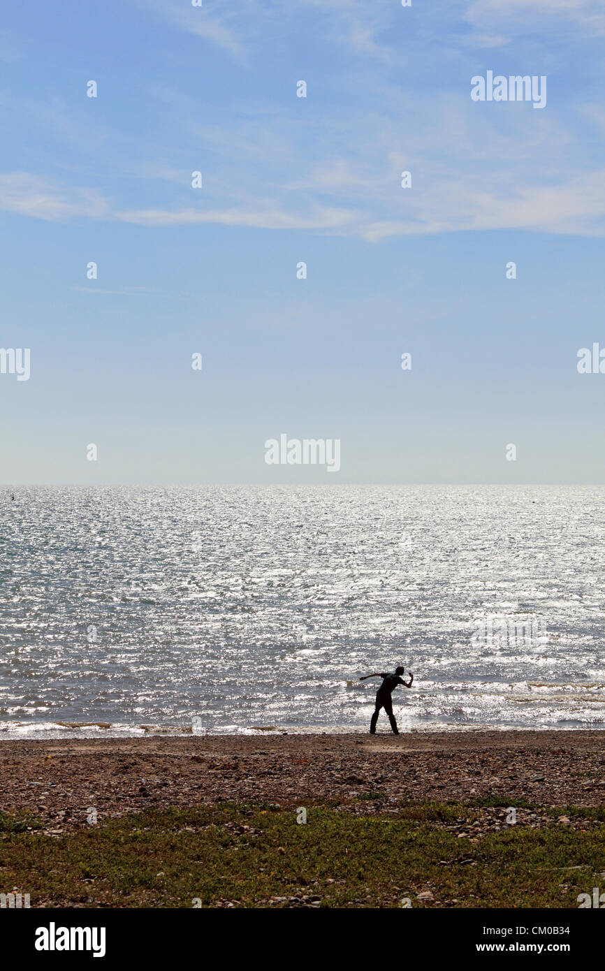 Goringbysea beach near Worthing, West Sussex, England, UK. Man throws