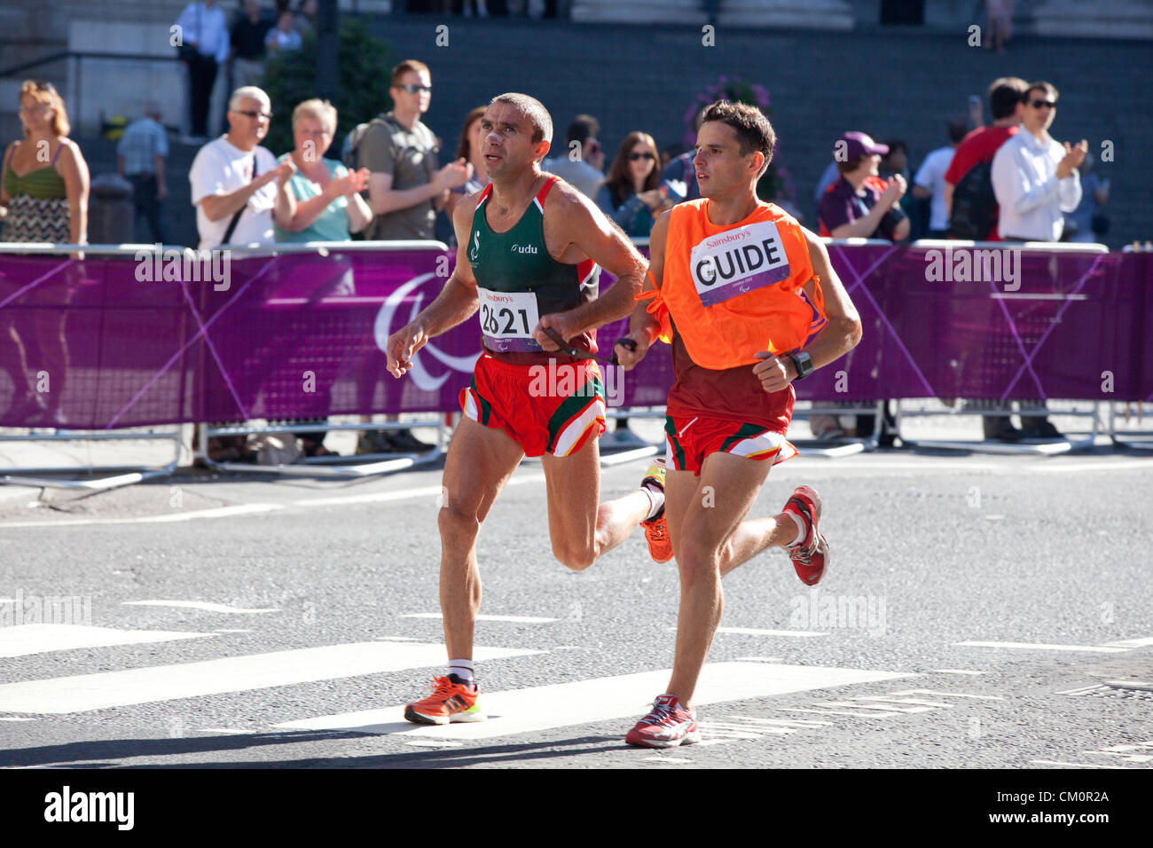 London, UK. 9th September 2012. T12 is the Paralympic Category for athletes with Visual Impairment. The runner here, Portugal's Joaquim Machado, with his guide,  passing by St. Paul Cathedral in the City of London. Stock Photo