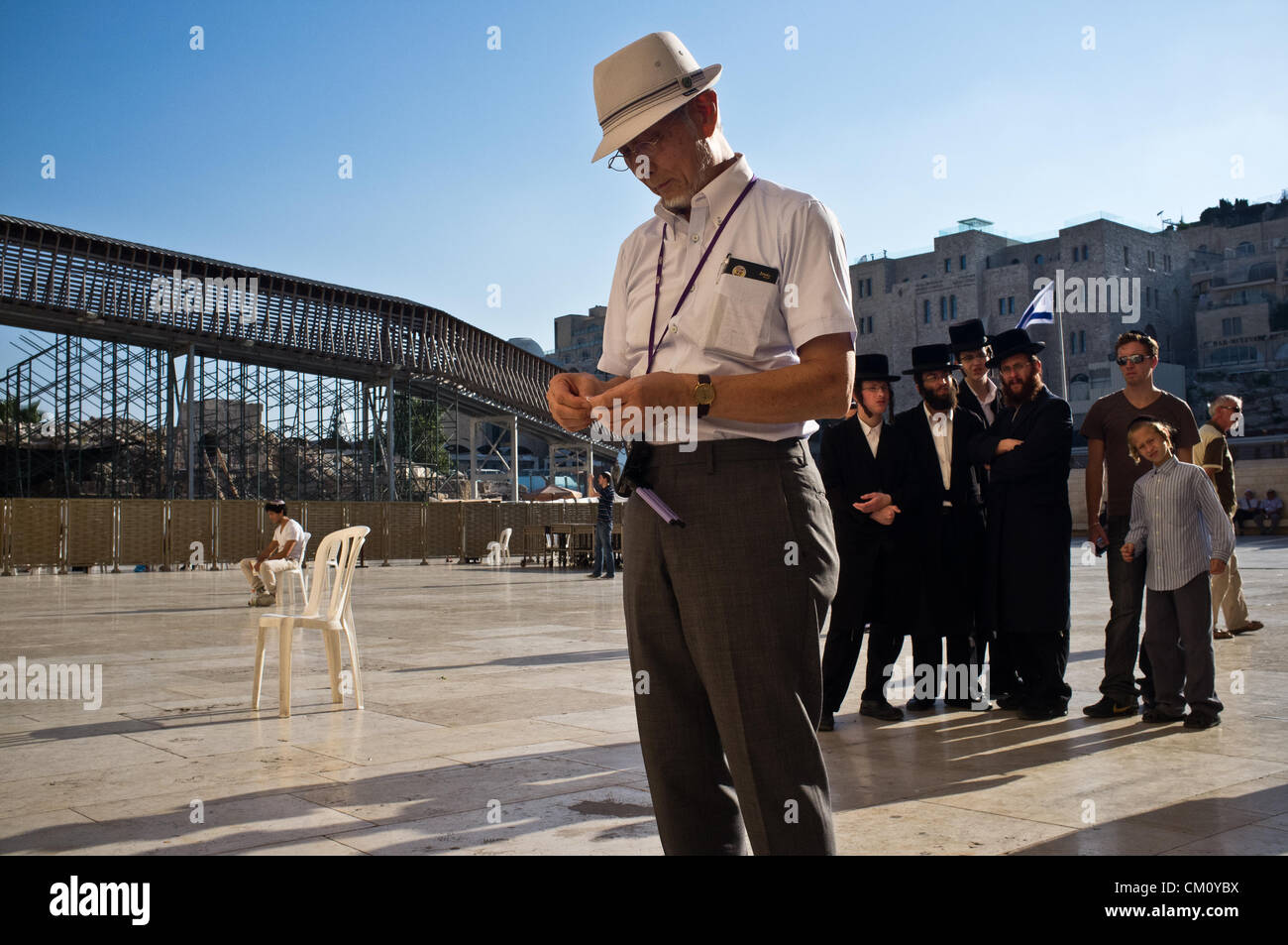 A Hibakusha, a Hiroshima child survivor, prepares what is perhaps the first origami crane prayer to be laid in the crevices between the Western wall stones in its 2,000 year history. Jerusalem, Israel. 10-September-2012.  Hibakusha, survivors of the August 6th, 1945 bombing of Hiroshima, visit Israel to promote nuclear abolition. Calling “No More Hiroshimas, No More Nagasakis!” they place their prayers between the Kotel stones. Stock Photo