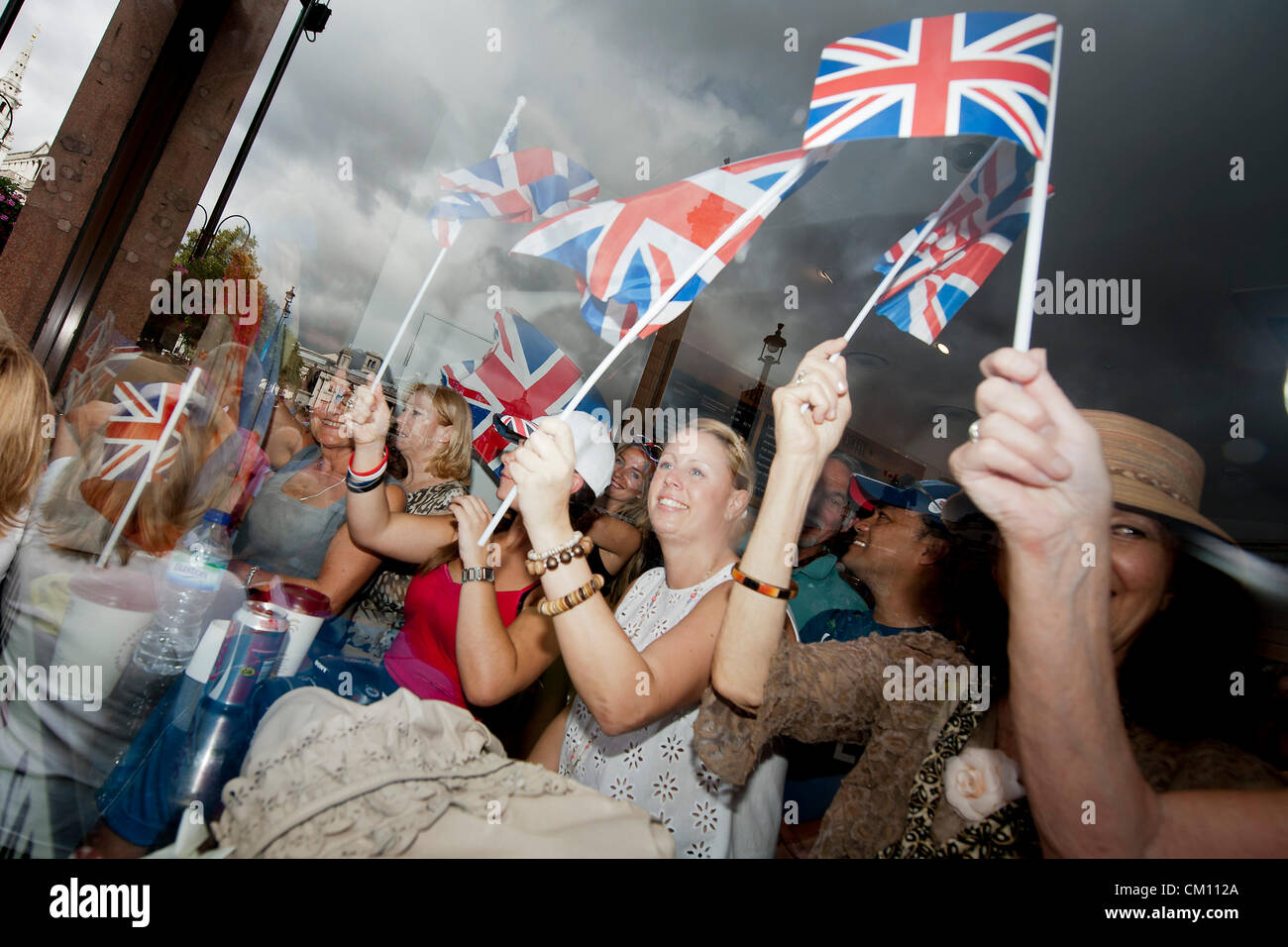 People watch from inside a sandwich shop. Team GB olympic and Paralympic parade.  Trafalgar Square, London, UK, 10 Sept 2012. Stock Photo