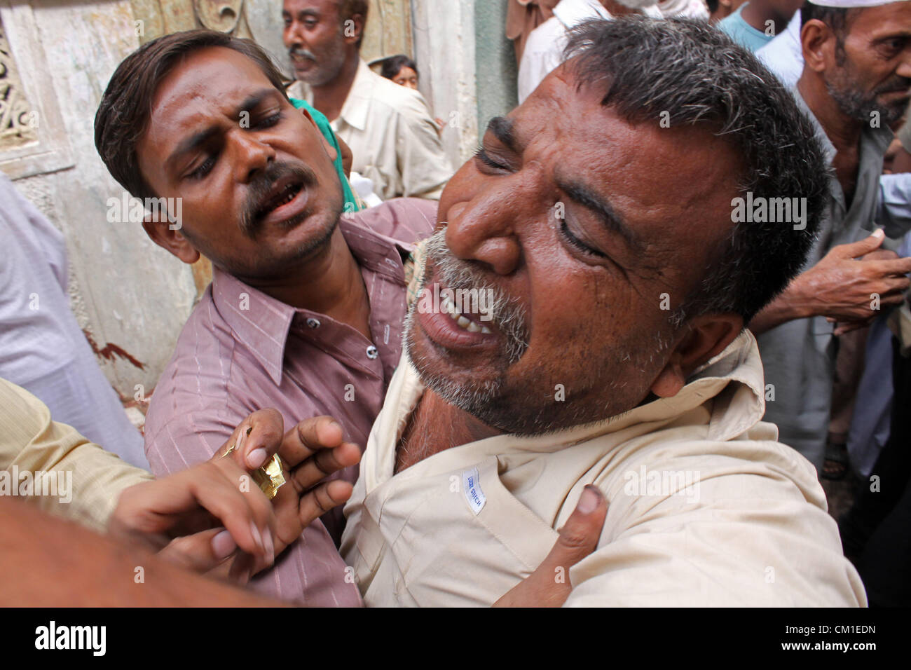Family members of two young brothers mourn during funeral procession in Karachi, Pakistan on September 13, 2012. At least 289 factory workers were burnt when wild fire engulfed a garment factory on Wednesday. Stock Photo