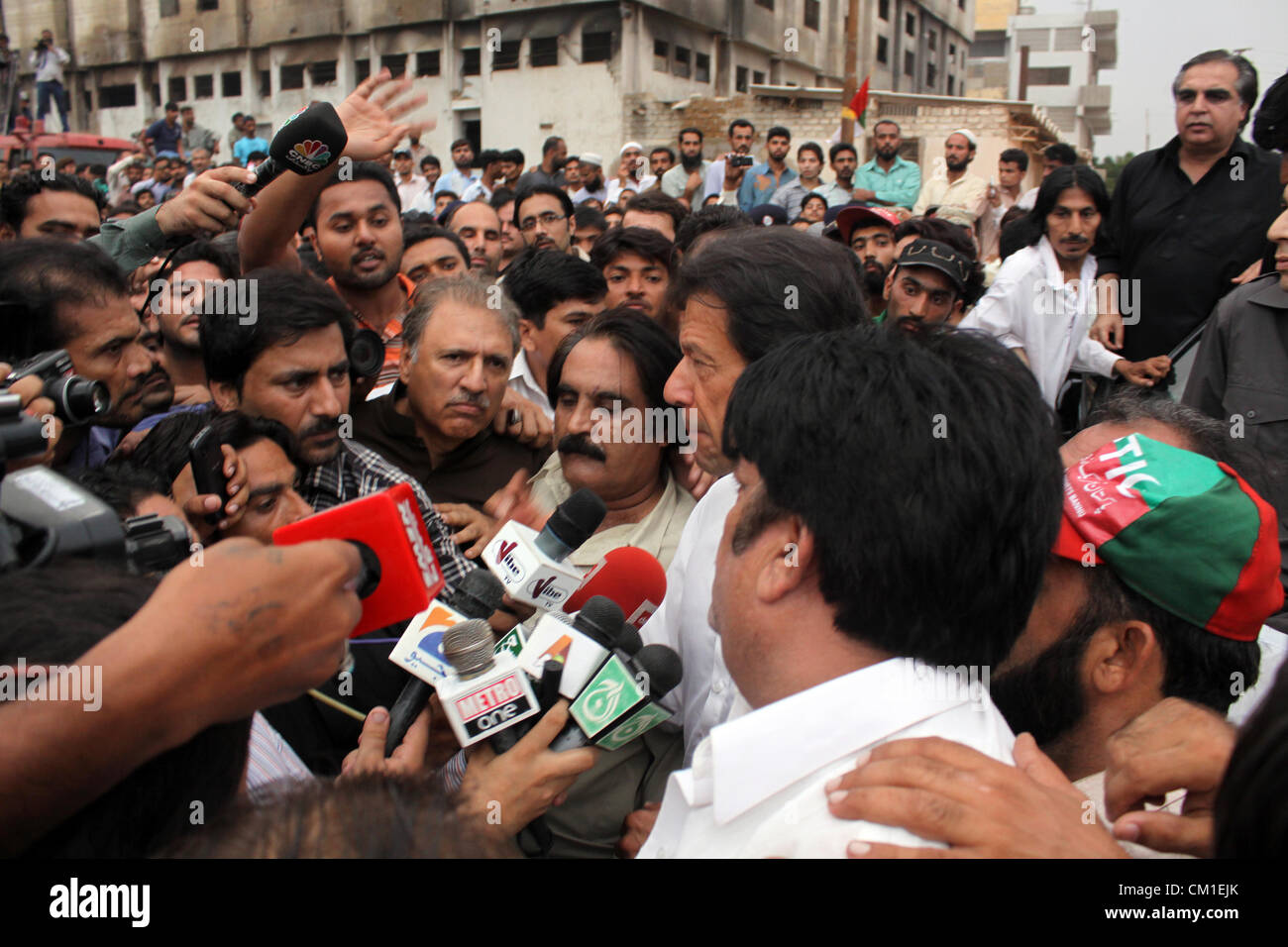 Chairman Pakistan Tehreek-e-Insaf (PTI) Imran Khan visits the burnt factory site in Karachi September 13, 2012. Atleast 289 factory workers were burnt when fire engulfed a garment factory on Wednesday. Stock Photo