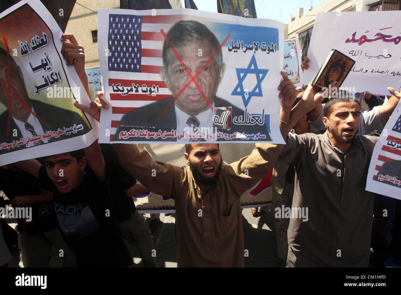 Sept. 14, 2012 - Gaza City, Gaza Strip, Palestinian Territory - Palestinians hold placards as they shout anti-U.S. slogans during a demonstration against the controversial film 'Innocence of Muslims' in Khan Younis southern Gaza strip, on September 14, 2012. The controversial low budget film reportedly made by an Israeli-American which portrays Muslims as immoral and gratuitous, sparked fury in Libya, where four Americans including the ambassador were killed on Tuesday when a mob attacked the US consulate in Benghazi, and has led to protests outside US missions in Morocco, Sudan, Egypt, Tunisi Stock Photo