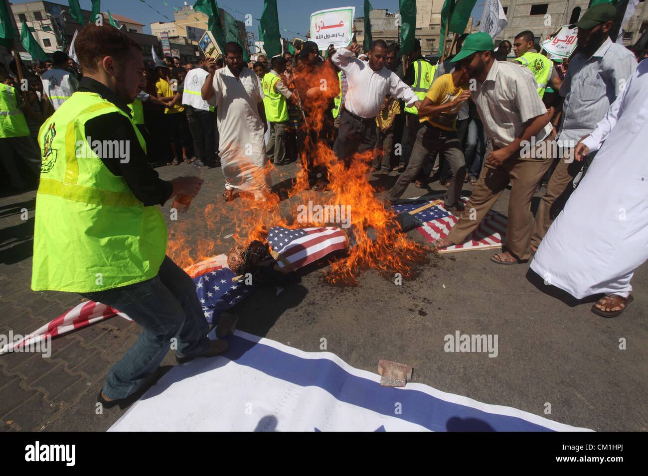 Sept. 14, 2012 - Gaza City, Gaza Strip, Palestinian Territory - Palestinians burn the Israeli and the U.S. flags during a demonstration against the controversial film 'Innocence of Muslims' in Khan Younis southern Gaza strip, on September 14, 2012. The controversial low budget film reportedly made by an Israeli-American which portrays Muslims as immoral and gratuitous, sparked fury in Libya, where four Americans including the ambassador were killed on Tuesday when a mob attacked the US consulate in Benghazi, and has led to protests outside US missions in Morocco, Sudan, Egypt, Tunisia and Yeme Stock Photo