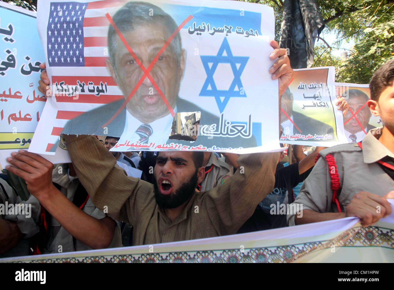 Sept. 14, 2012 - Gaza City, Gaza Strip, Palestinian Territory - Palestinians hold placards as they shout anti-U.S. slogans during a demonstration against the controversial film 'Innocence of Muslims' in Khan Younis southern Gaza strip, on September 14, 2012. The controversial low budget film reportedly made by an Israeli-American which portrays Muslims as immoral and gratuitous, sparked fury in Libya, where four Americans including the ambassador were killed on Tuesday when a mob attacked the US consulate in Benghazi, and has led to protests outside US missions in Morocco, Sudan, Egypt, Tunisi Stock Photo